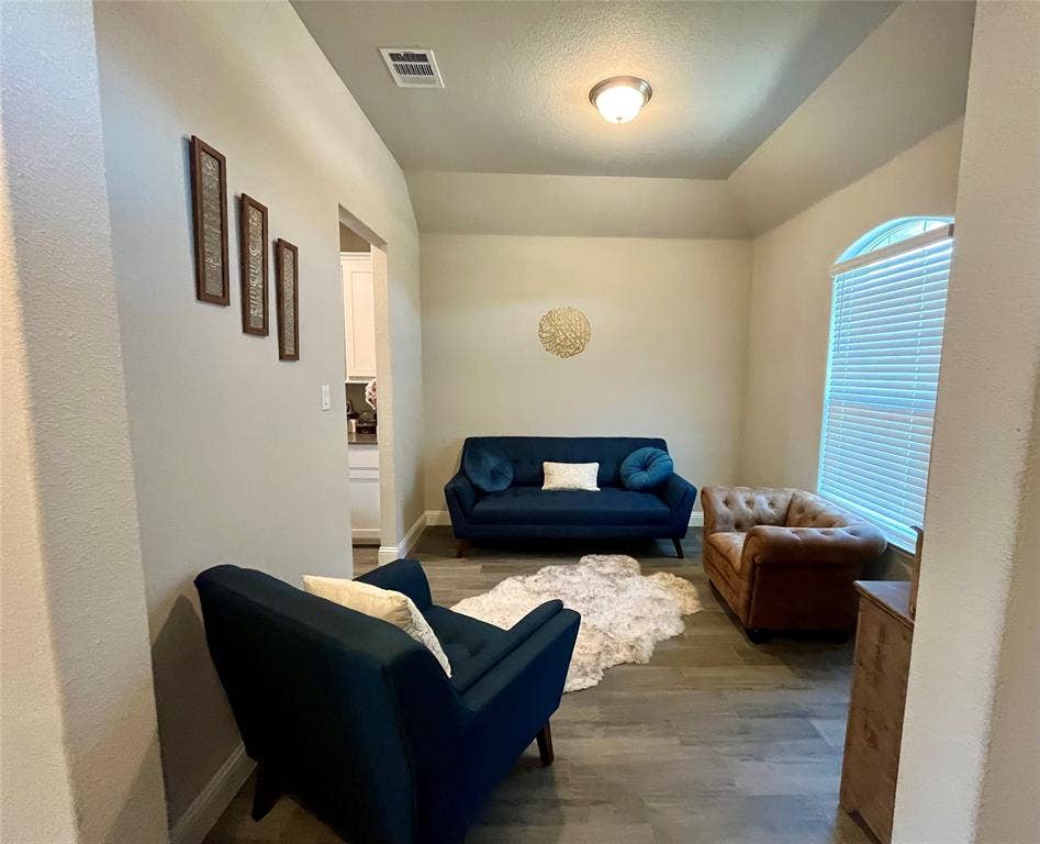 3636 Wintergreen Street, Grand Prairie, TX 76065 Tray ceiling with recessed lighting, arched window, and wood-finish flooring