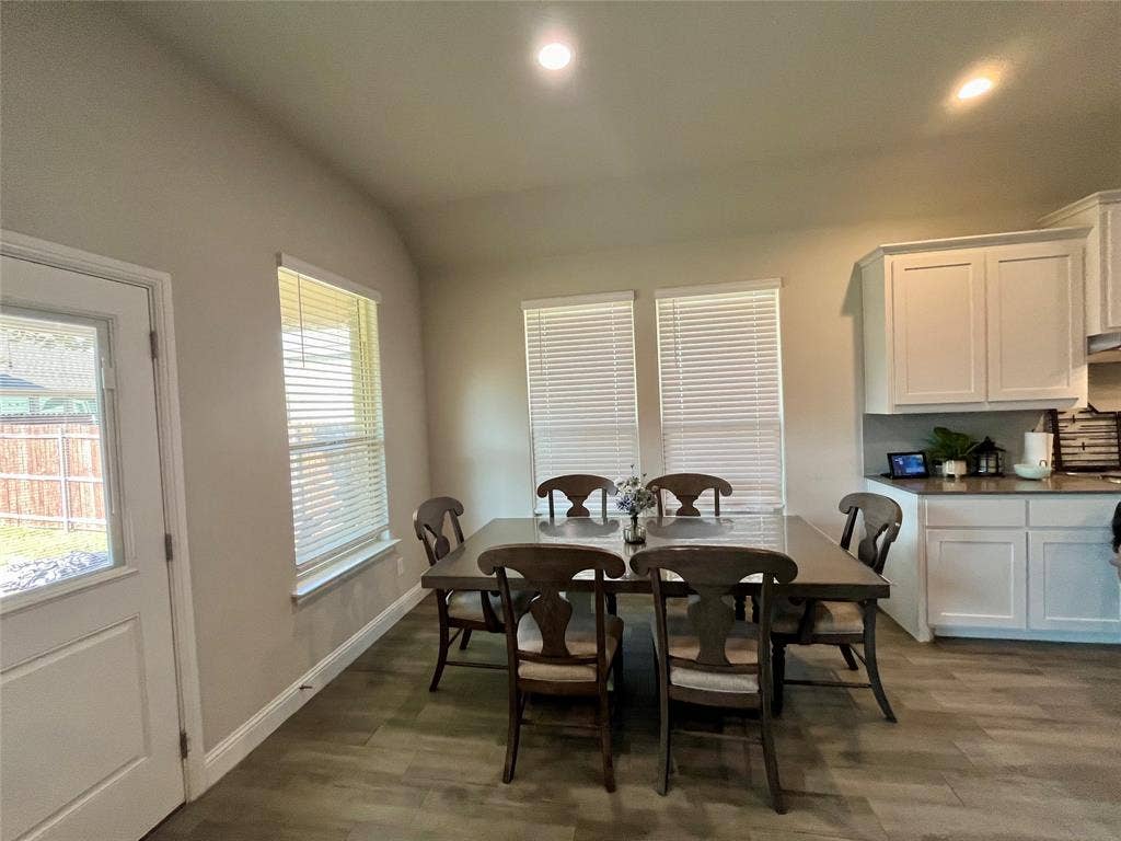 3636 Wintergreen Street, Grand Prairie, TX 76065 Wood-finish flooring, recessed lighting, white cabinetry, and multiple windows with blinds