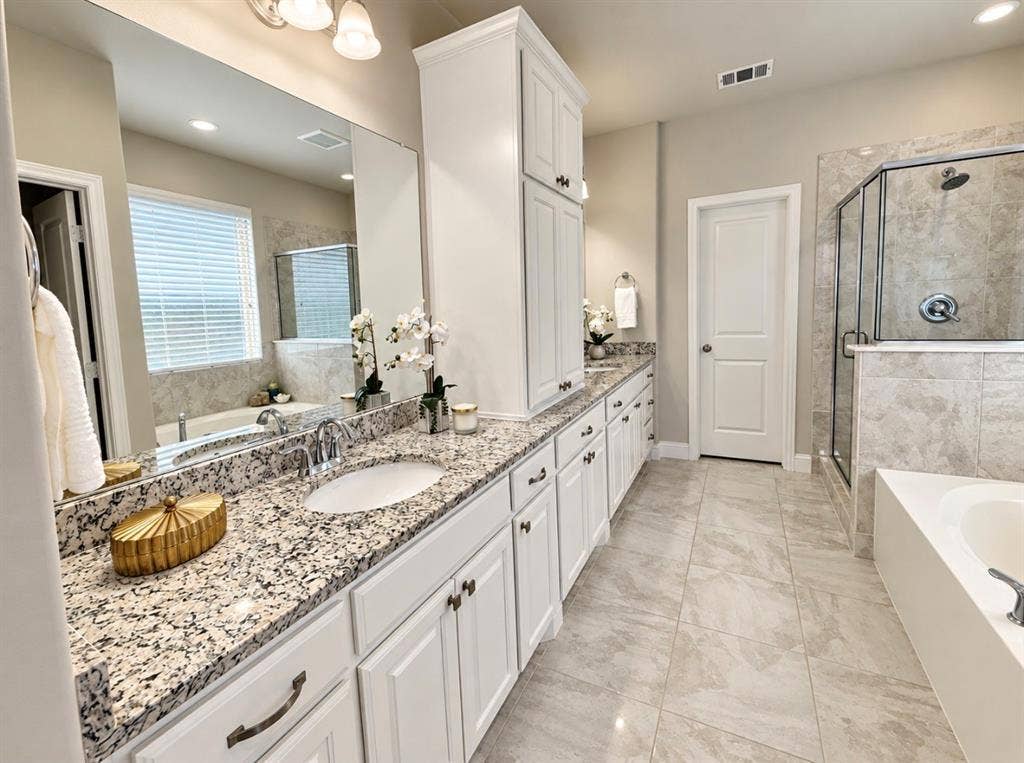 16116 Plum Court, Prosper, TX 75078 Dual vanity with undermount sinks, stone countertops, white shaker cabinetry, tiled flooring, and a glass-enclosed shower