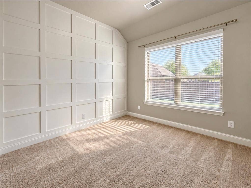 16116 Plum Court, Prosper, TX 75078 Accent wall with grid paneling, neutral carpeting, and a large window with blinds