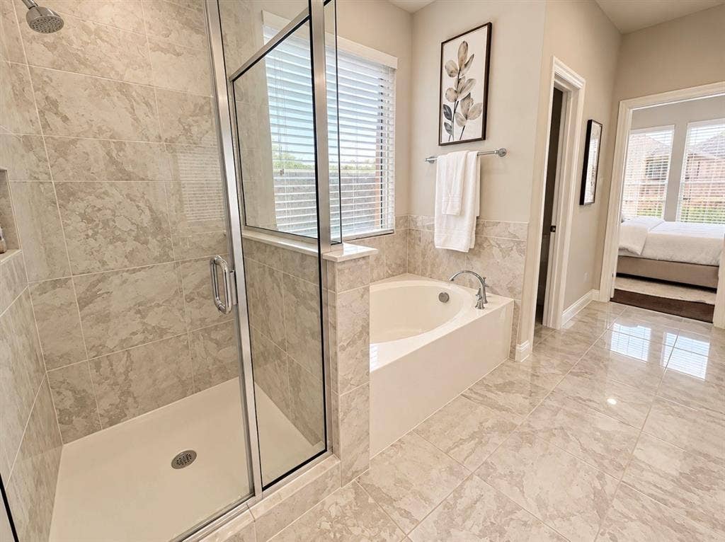 16116 Plum Court, Prosper, TX 75078 Tiled bathroom with a glass-enclosed shower, built-in shower niche, and a corner soaking tub