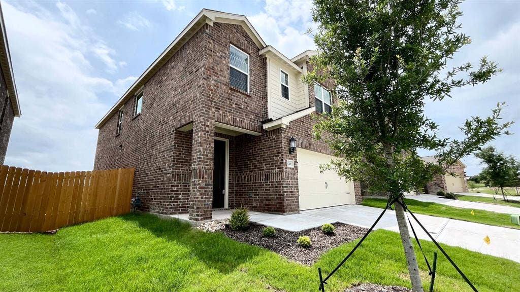 1101 Princeton Heights, Princeton, TX 75407 Two-story brick exterior with light-colored siding accents, an attached garage, a covered entryway, and a fenced yard