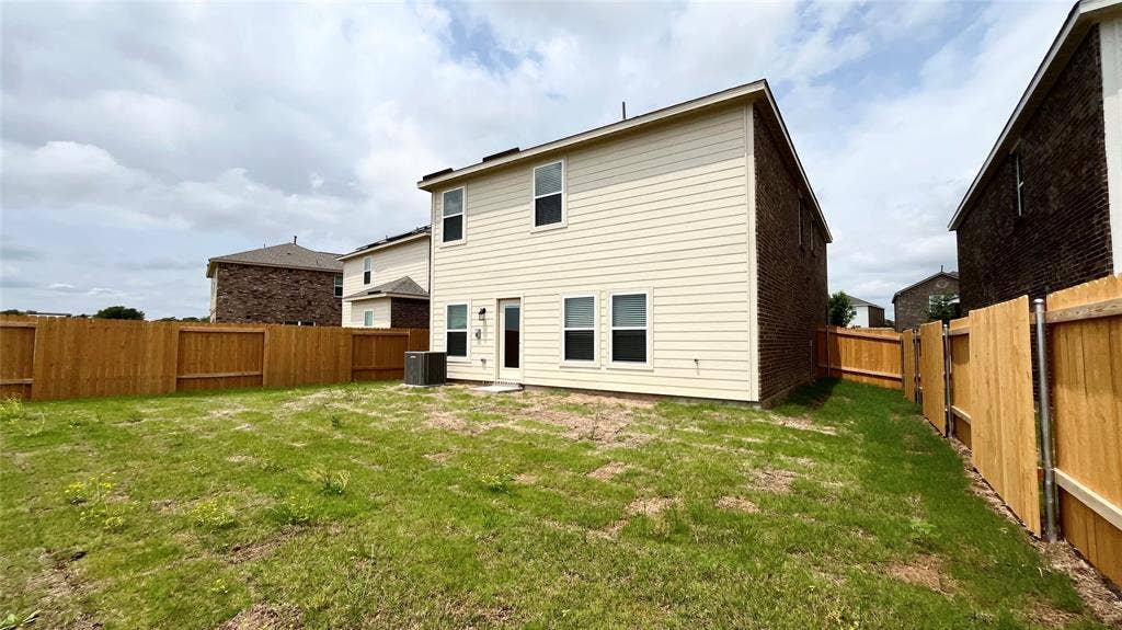 1101 Princeton Heights, Princeton, TX 75407 Expansive rear yard featuring wood privacy fencing, a ground-level patio, and a two-story exterior with siding and brick accents