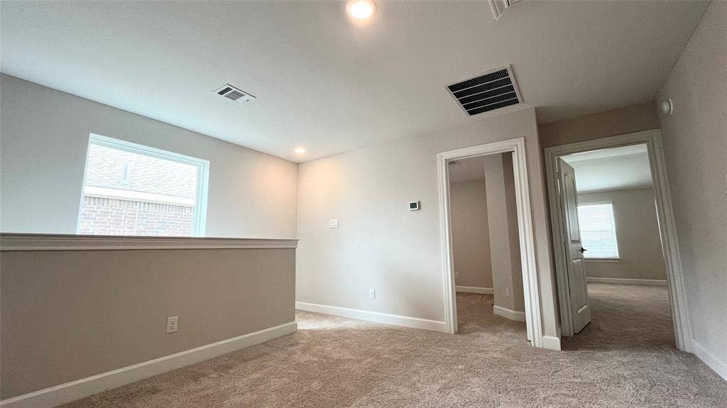 1101 Princeton Heights, Princeton, TX 75407 Carpeted upper-level landing with neutral wall tones, recessed lighting, and a white framed window
