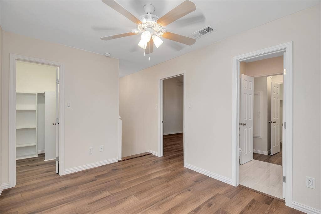 3635 Garden Brook Drive, #20200L, Farmers Branch, TX 75234 Wood-finish flooring, ceiling fan with integrated lighting, multiple doorways, and neutral wall tones