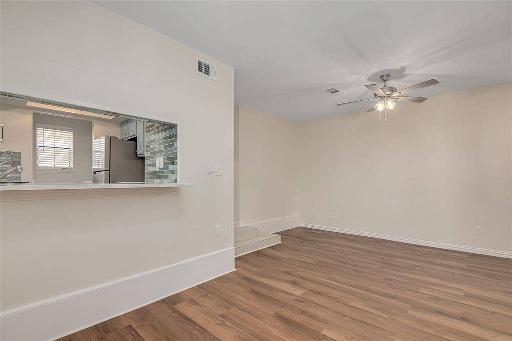 3635 Garden Brook Drive, #20200L, Farmers Branch, TX 75234 Wood-finish flooring, ceiling fan with integrated lighting, pass-through window with countertop, and subway tile backsplash