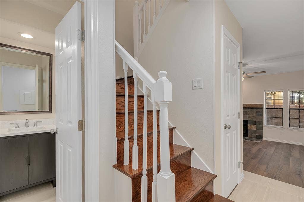 3635 Garden Brook Drive, #20200L, Farmers Branch, TX 75234 Wood-finish staircase with white balusters, leading to an upper level
