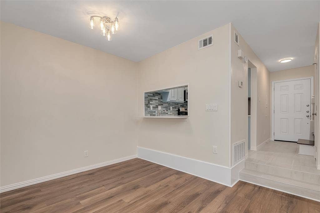 3635 Garden Brook Drive, #20200L, Farmers Branch, TX 75234 Wood-finish flooring, contemporary chandelier, pass-through kitchen opening, tiled entry, and recessed lighting
