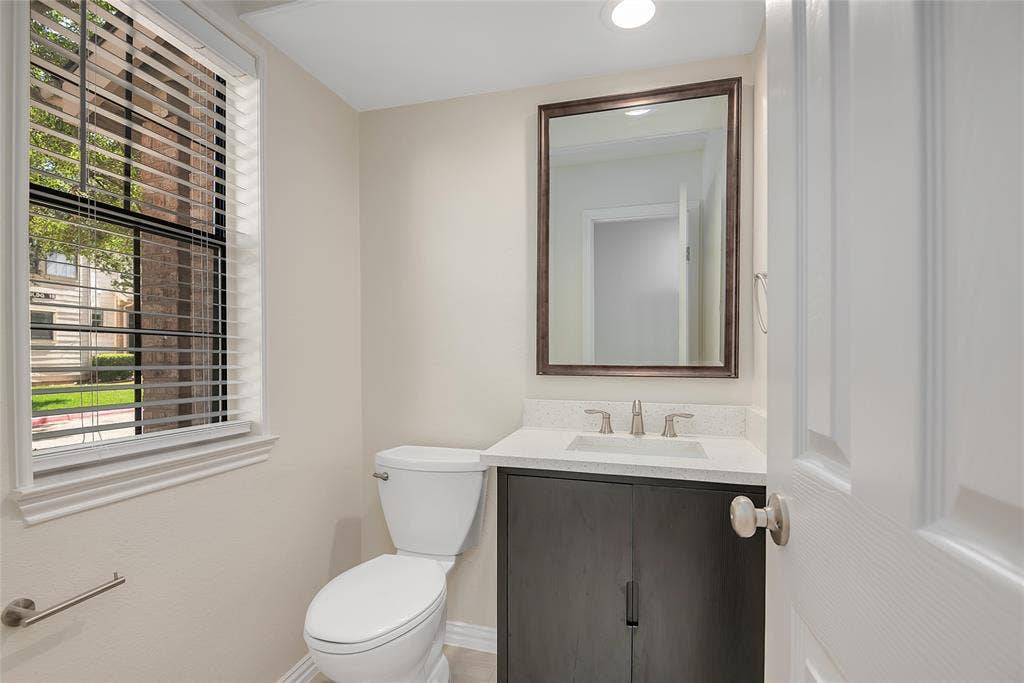 3635 Garden Brook Drive, #20200L, Farmers Branch, TX 75234 Recessed lighting, framed mirror, wood-finish vanity with a light-toned countertop, and a window with horizontal blinds