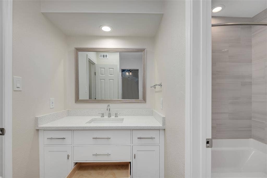 3635 Garden Brook Drive, #20200L, Farmers Branch, TX 75234 White vanity with brushed nickel hardware, integrated sink, and light-toned countertop