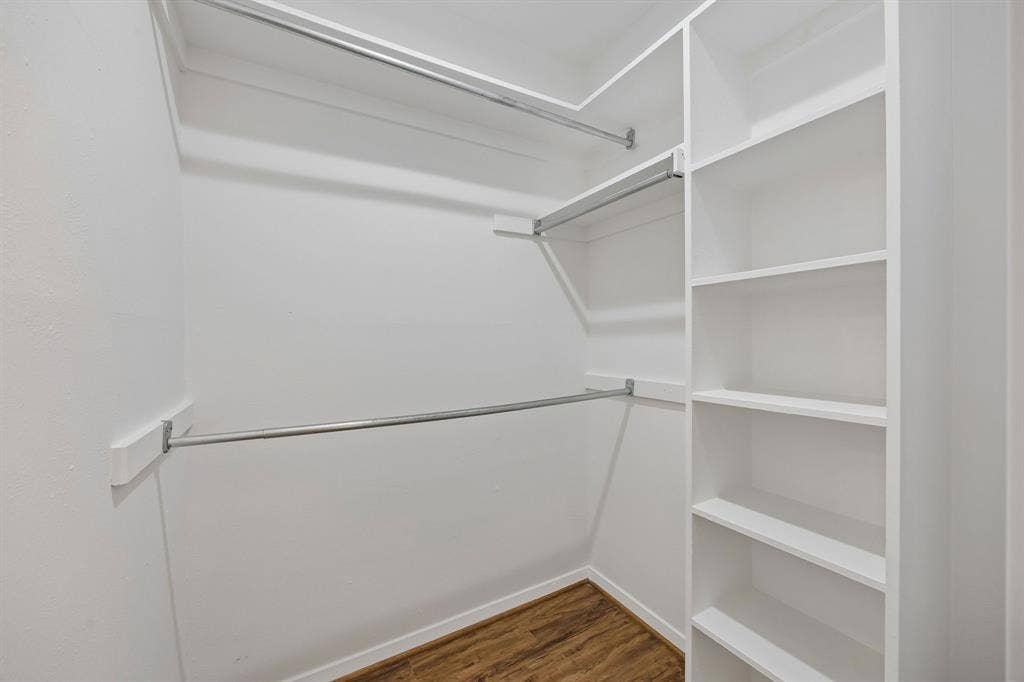 1613 19th Street, Plano, TX 75074 Built-in shelving, multiple hanging rods, and wood-finish flooring