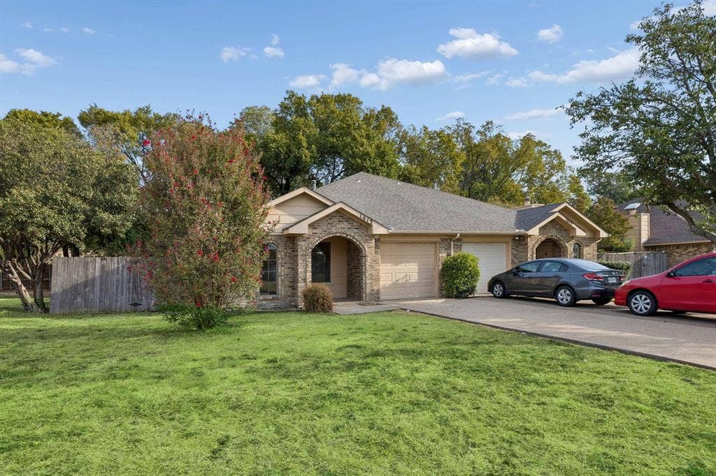 1613 19th Street, Plano, TX 75074 Exterior featuring a brick and siding facade, arched entryways, a shingle roof, and an attached one-car garage