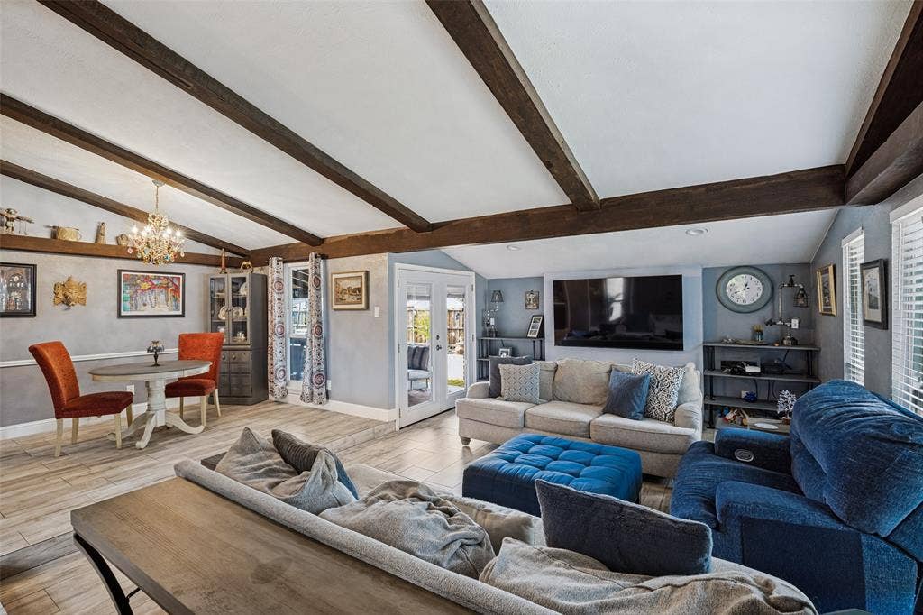 1216 Lombardy Drive, Plano, TX 75023 Vaulted ceiling with exposed wood beams, French doors, chandelier, wood-finish flooring, and built-in shelving