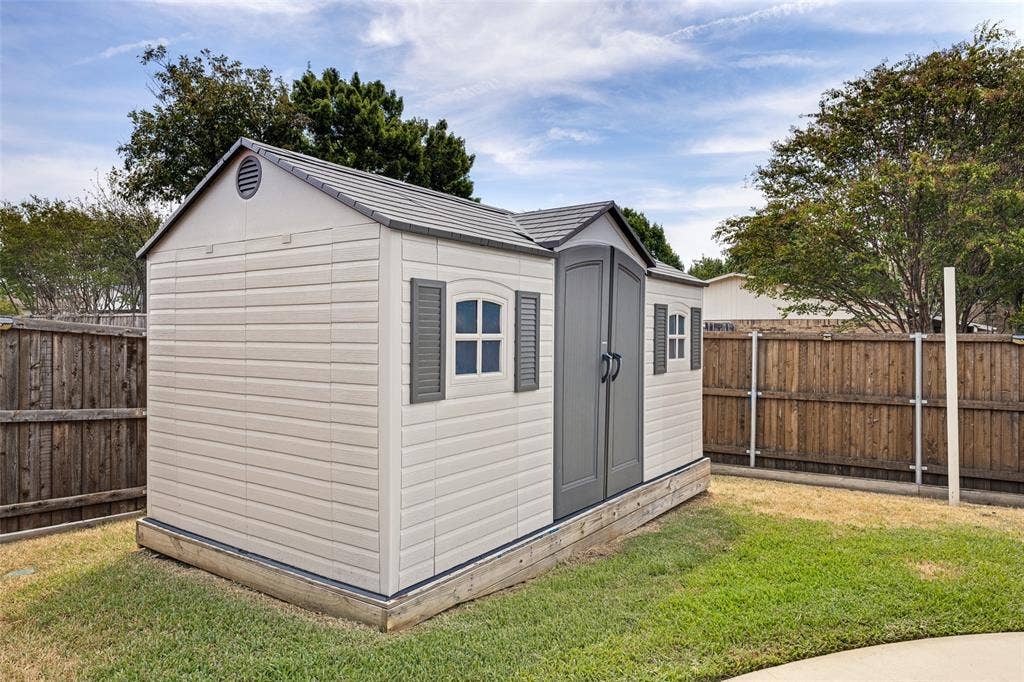 1216 Lombardy Drive, Plano, TX 75023 Outdoor storage shed with a gabled roof, double doors, and decorative windows