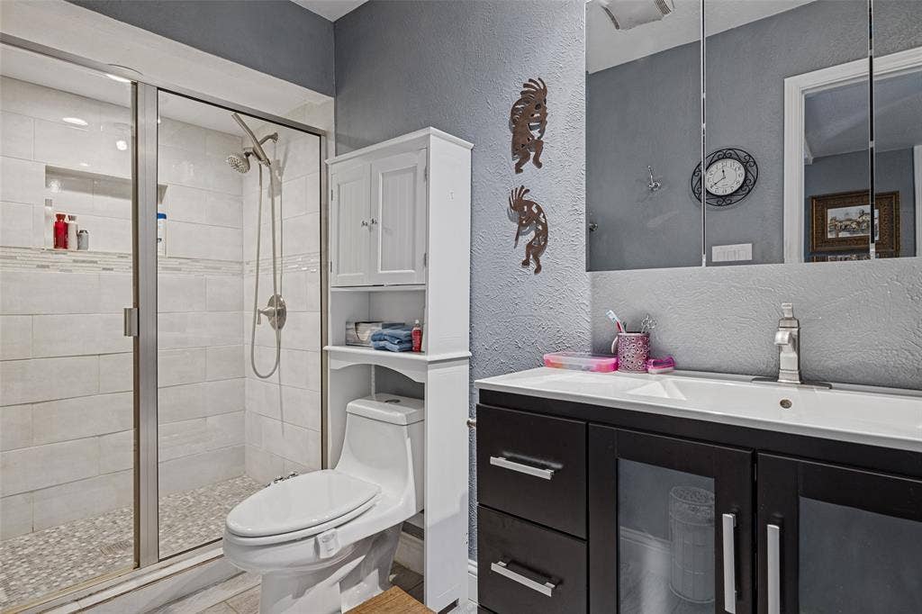 1216 Lombardy Drive, Plano, TX 75023 Glass-enclosed shower with tiled walls and pebble floor
