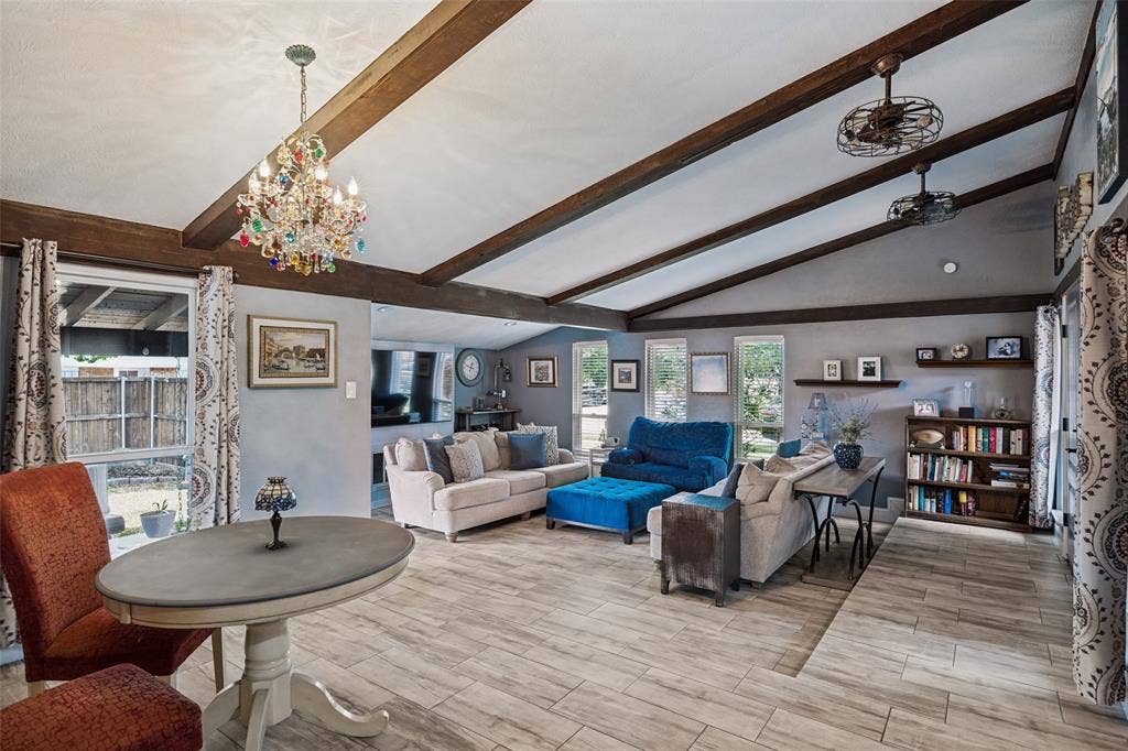 1216 Lombardy Drive, Plano, TX 75023 Vaulted ceiling with exposed wood beams, wood-finish flooring, multiple windows, built-in shelving, and a decorative chandelier