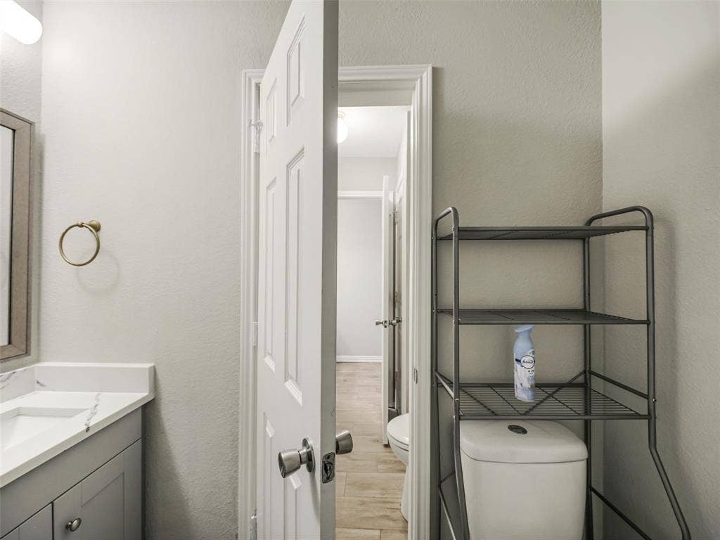 Vanity with integrated sink and countertop, framed mirror, and panel door