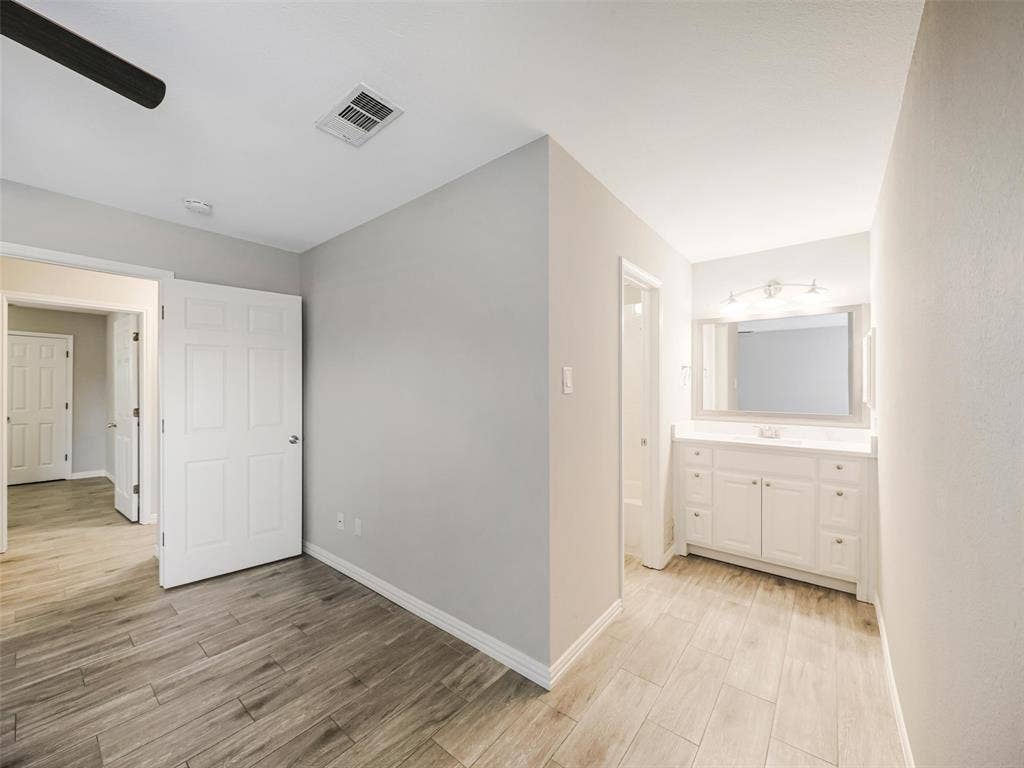 Light wood-finish flooring extends through the space