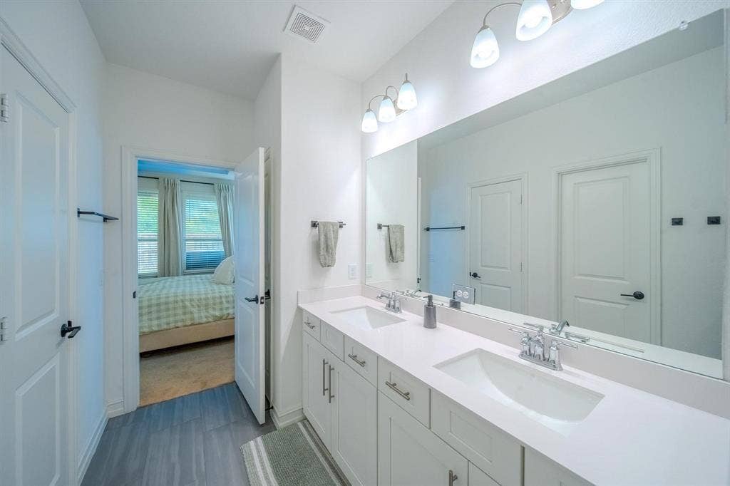 4629 Golden Gate Way, Garland, TX 75043 Dual vanity with undermount sinks, chrome fixtures, and a large mirror