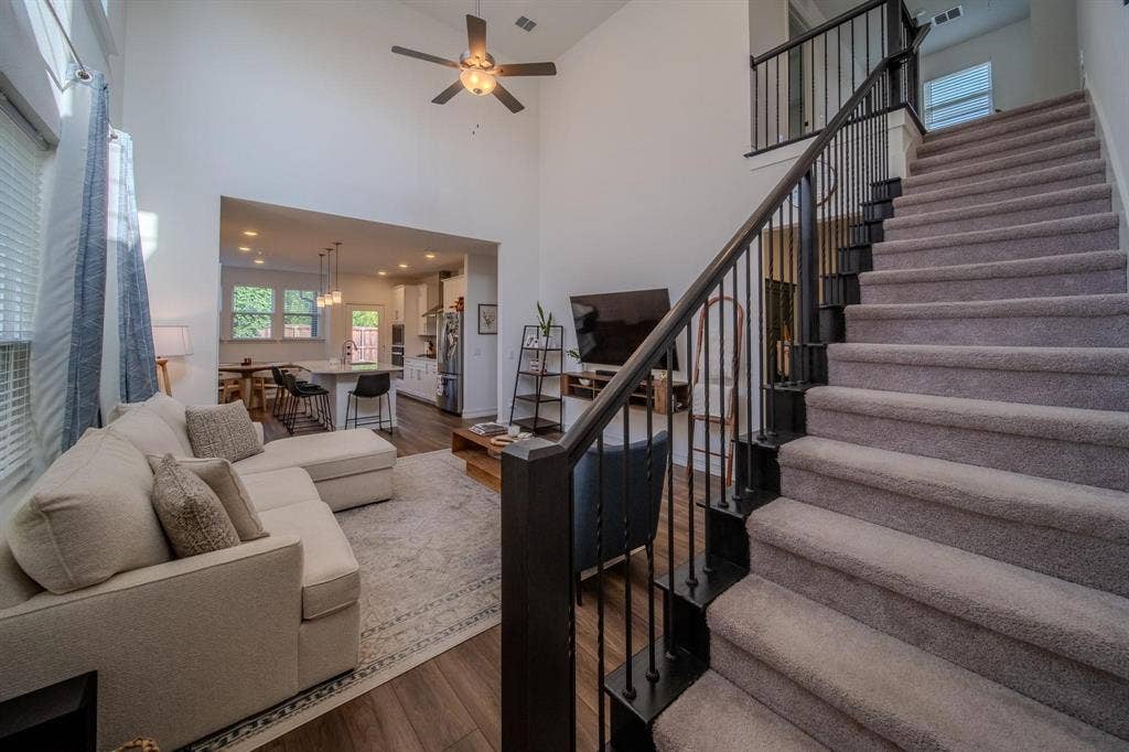4629 Golden Gate Way, Garland, TX 75043 Two-story ceiling, wood-finish flooring, open-concept design, recessed lighting, and a contemporary staircase with metal balusters