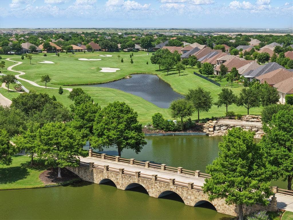 Aerial perspective of bridge, ponds, and golf course at Robson Ranch main entrance.