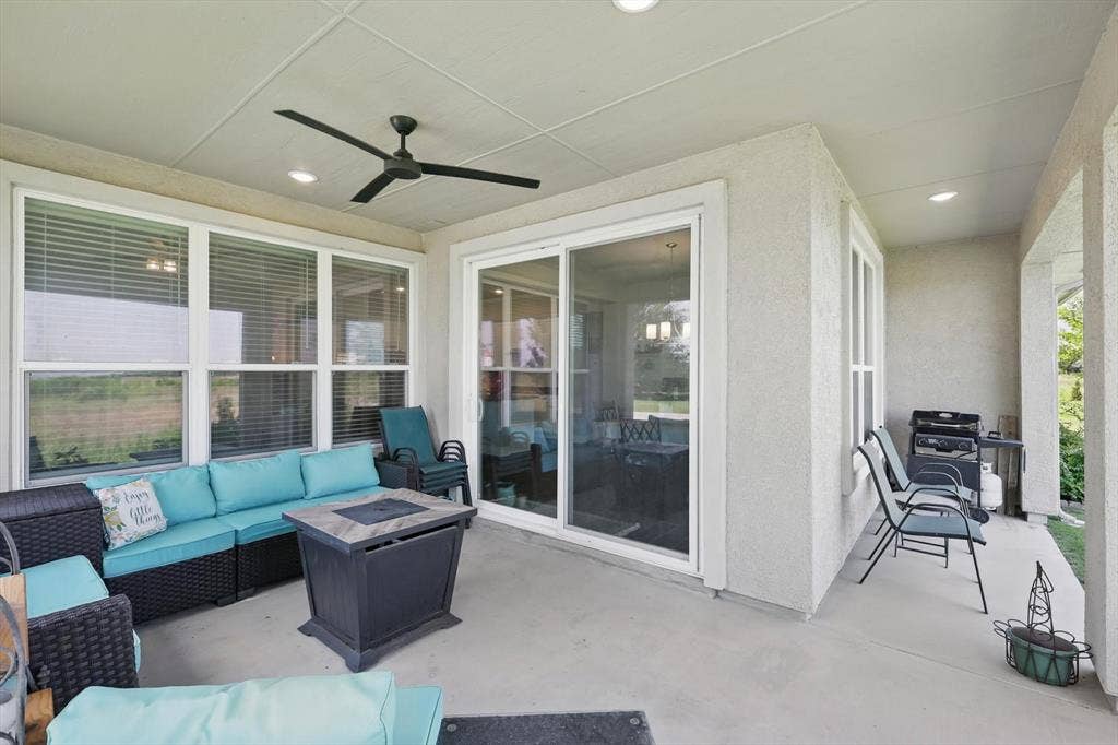 View of patio with an outdoor living space with a ceiling fan.