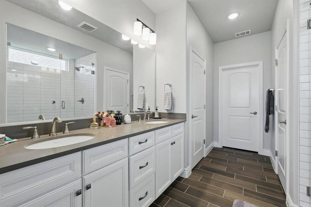 Bathroom with a double vanity, large linen closet, and walk-in closet with plug.