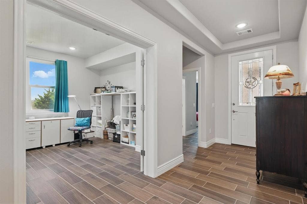Office or craft room with tray ceiling and double doors for privacy.