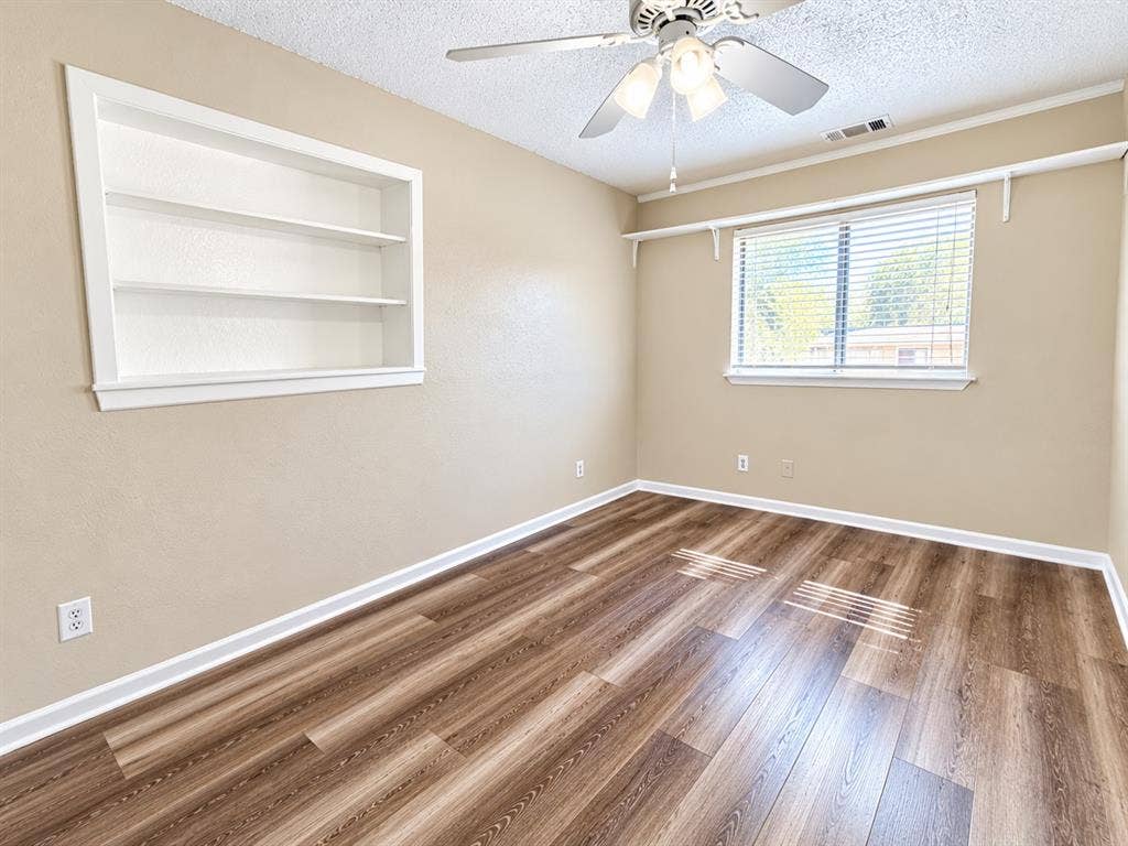 1500 Sherrye Drive, Plano, TX 75074 Wood-finish flooring, built-in shelving, ceiling fan, window with blinds, and white trim throughout