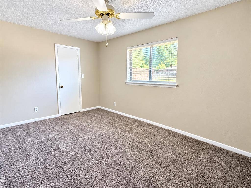 1500 Sherrye Drive, Plano, TX 75074 Neutral tone wall color, textured ceiling, brown patterned carpet, white window trim, and a ceiling fan with integrated lighting