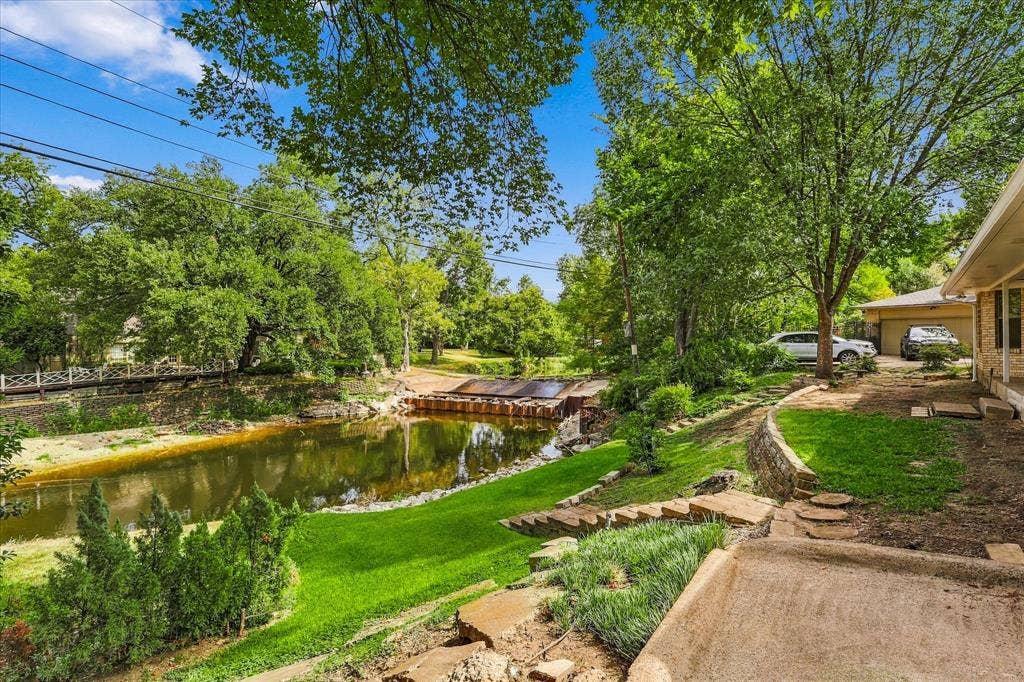 2811 Reedcroft Drive, Farmers Branch, TX 75234 Expansive outdoor space featuring a water element, terraced landscaping, and a stone retaining wall