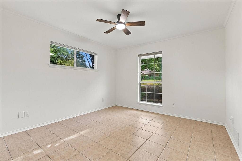 2811 Reedcroft Drive, Farmers Branch, TX 75234 Neutral tone wall finishes, tiled flooring, two distinct windows, and a ceiling fan with integrated lighting