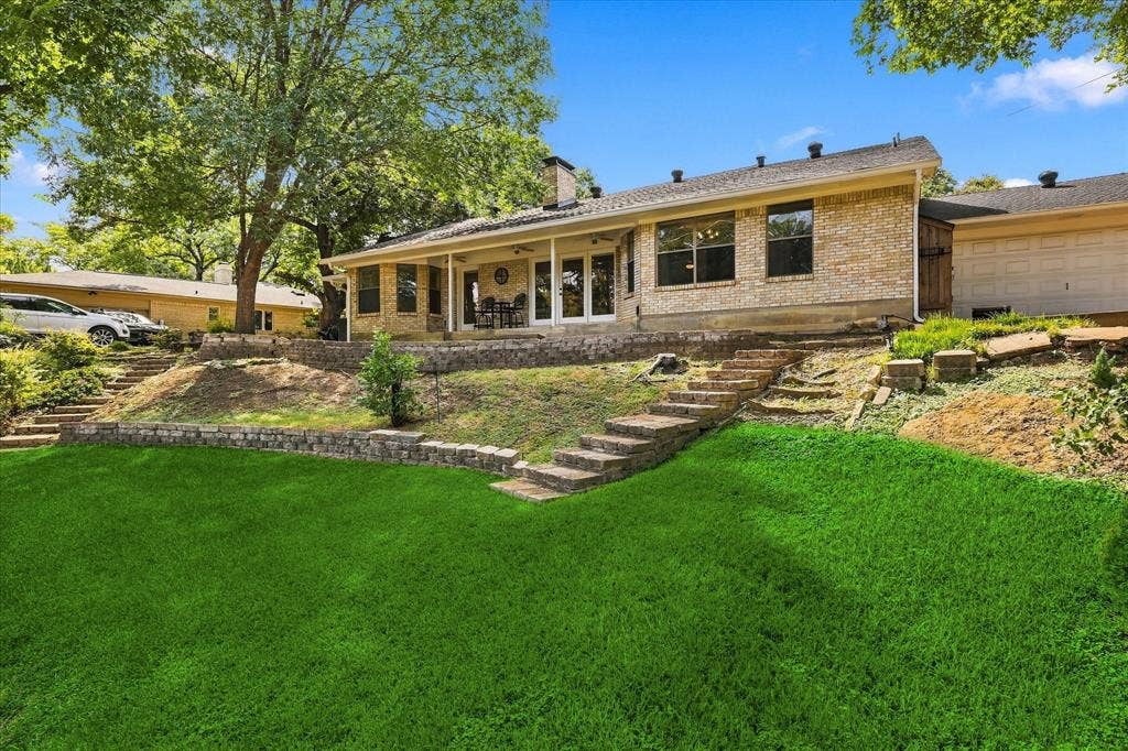 2811 Reedcroft Drive, Farmers Branch, TX 75234 Brick exterior with a covered patio, multiple windows, and a two-car garage