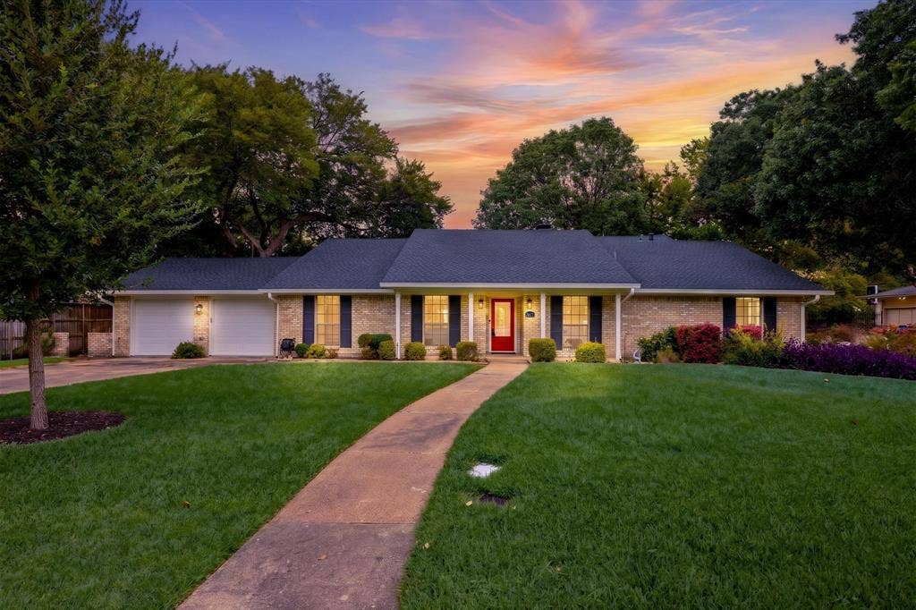 2811 Reedcroft Drive, Farmers Branch, TX 75234 Single-story brick residence featuring a two-car garage, a dark shingle roof, and a red front door
