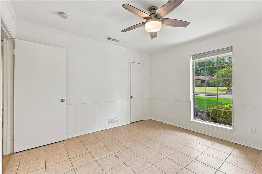 2811 Reedcroft Drive, Farmers Branch, TX 75234 Tile flooring, white paneled wainscoting, ceiling fan with integrated lighting, crown molding, and a large window