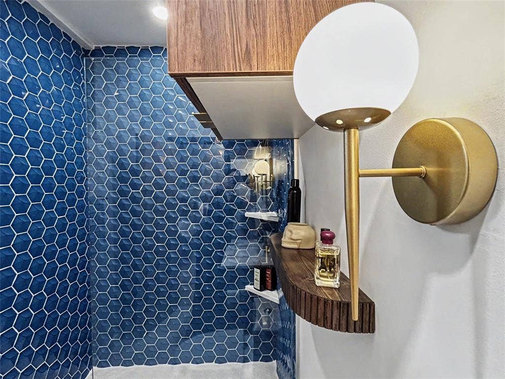 11737 Rogue Way, Dallas, TX 75218 Primary en-suite bath featuring blue hex tile and statement sconces