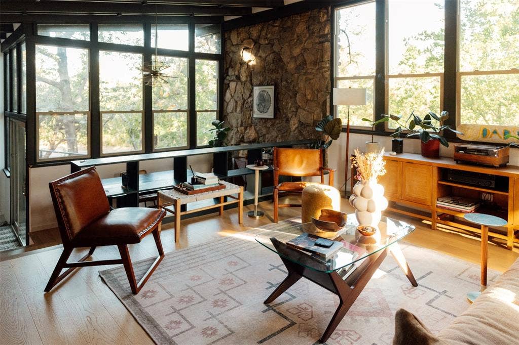 11737 Rogue Way, Dallas, TX 75218 Rock wall, starburst chandelier, and treetop views in the main living room