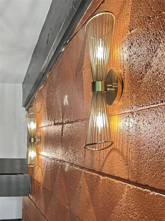 11737 Rogue Way, Dallas, TX 75218 Brass sconces glowing on the mid-century textured orange wall
