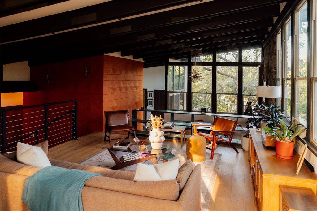 11737 Rogue Way, Dallas, TX 75218 Orange block wall, dark beams, and cable rail in the main living room
