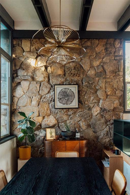 11737 Rogue Way, Dallas, TX 75218 Dining room a half level up, with stone wall and brass chandelier