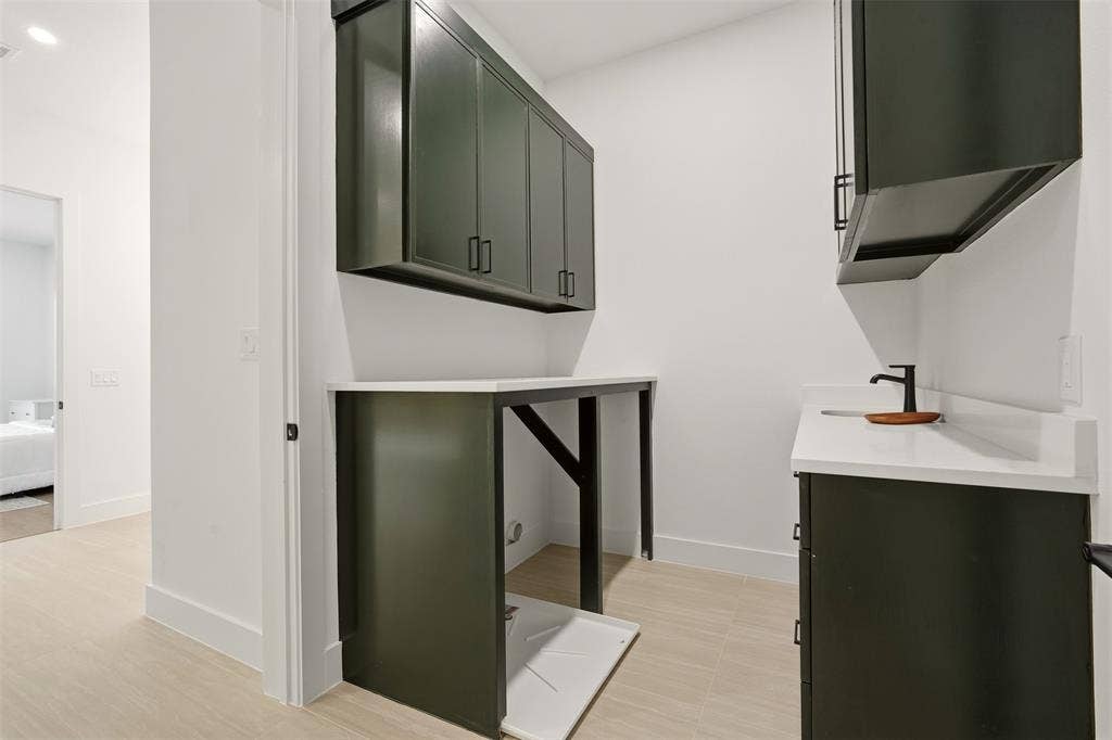 6911 Mohawk, Dallas, TX 75235 Dark-toned cabinetry with matte black hardware, white countertops, and a black faucet