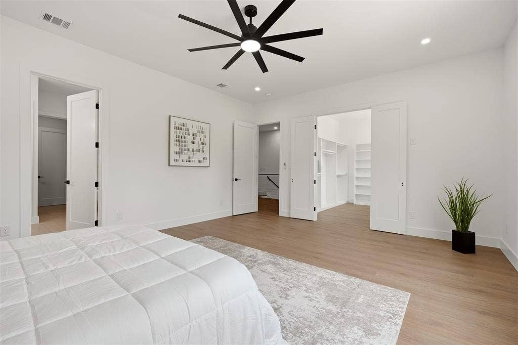 6911 Mohawk, Dallas, TX 75235 Spacious room featuring wood-finish flooring, a modern black ceiling fan, recessed lighting, and a built-in walk-in closet with shelving
