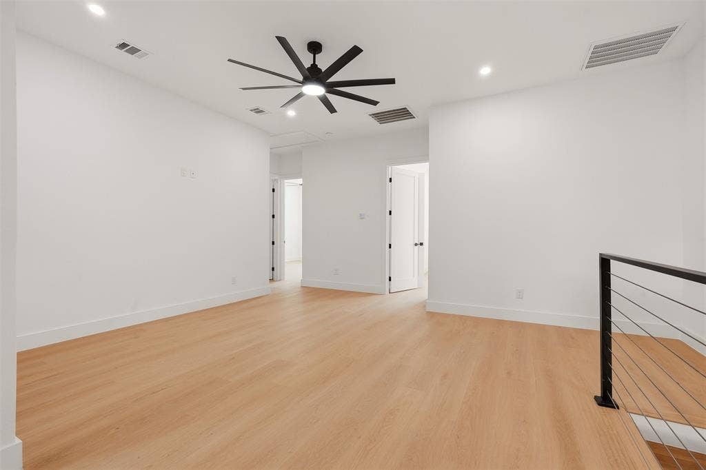6911 Mohawk, Dallas, TX 75235 Wood-finish flooring, recessed lighting, ceiling fan, white walls, and modern metal railing