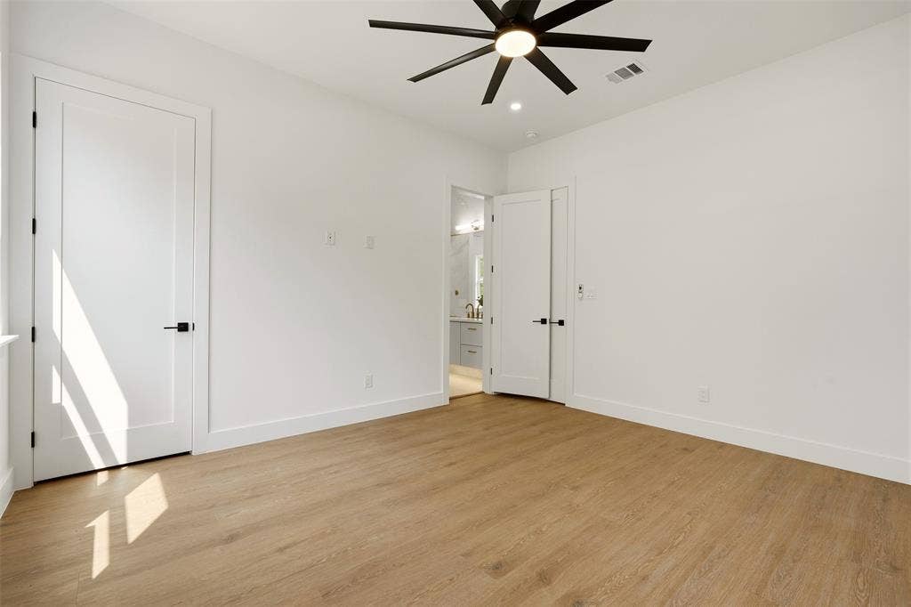 6911 Mohawk, Dallas, TX 75235 Wood-finish flooring, crisp white walls, contemporary ceiling fan, modern interior doors with matte black hardware, and bright recessed lighting