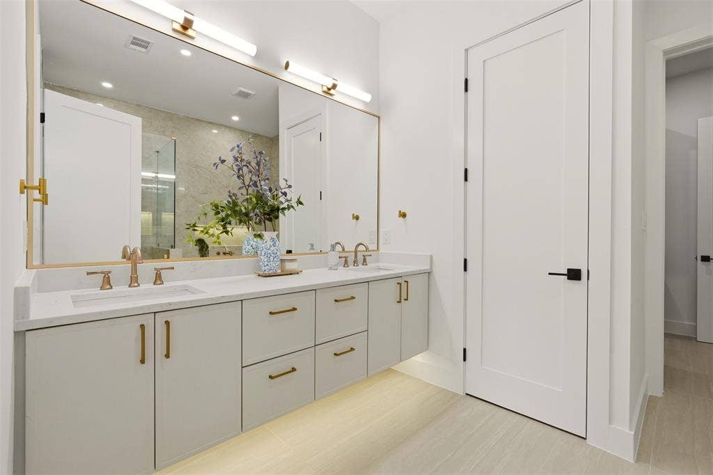 6911 Mohawk, Dallas, TX 75235 Dual vanity with integrated sinks, quartz countertop, contemporary gold-tone hardware, and under-cabinet lighting