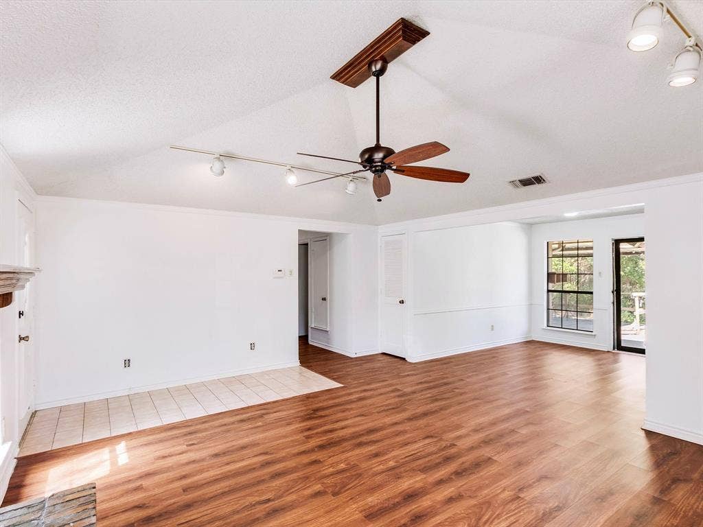 219 N Beltwoods Drive, DeSoto, TX 75115 Vaulted ceiling, wood-finish flooring, ceiling fan, track lighting, and a glass-paneled exterior door