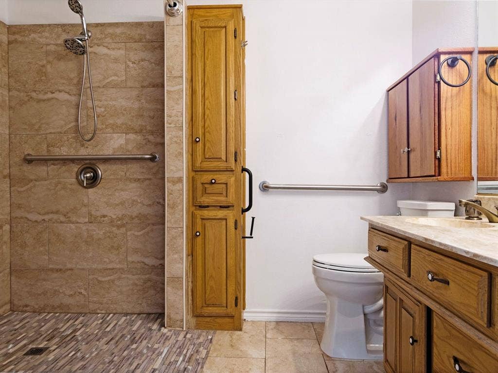 219 N Beltwoods Drive, DeSoto, TX 75115 Walk-in shower with natural-toned wall tile and multi-toned floor tile