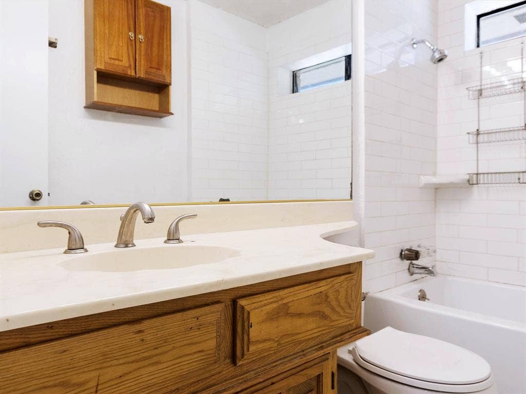 219 N Beltwoods Drive, DeSoto, TX 75115 Vanity with wood-finish cabinetry, integrated sink, and brushed nickel faucet