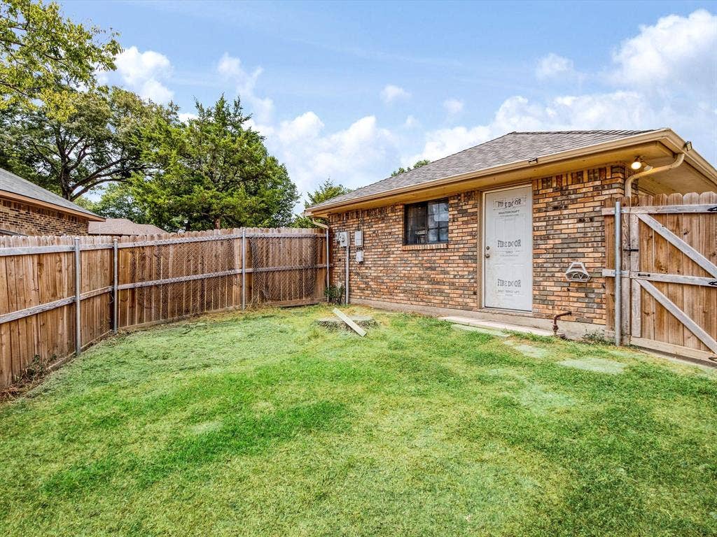 219 N Beltwoods Drive, DeSoto, TX 75115 Brick exterior with a gabled roof and wood fence