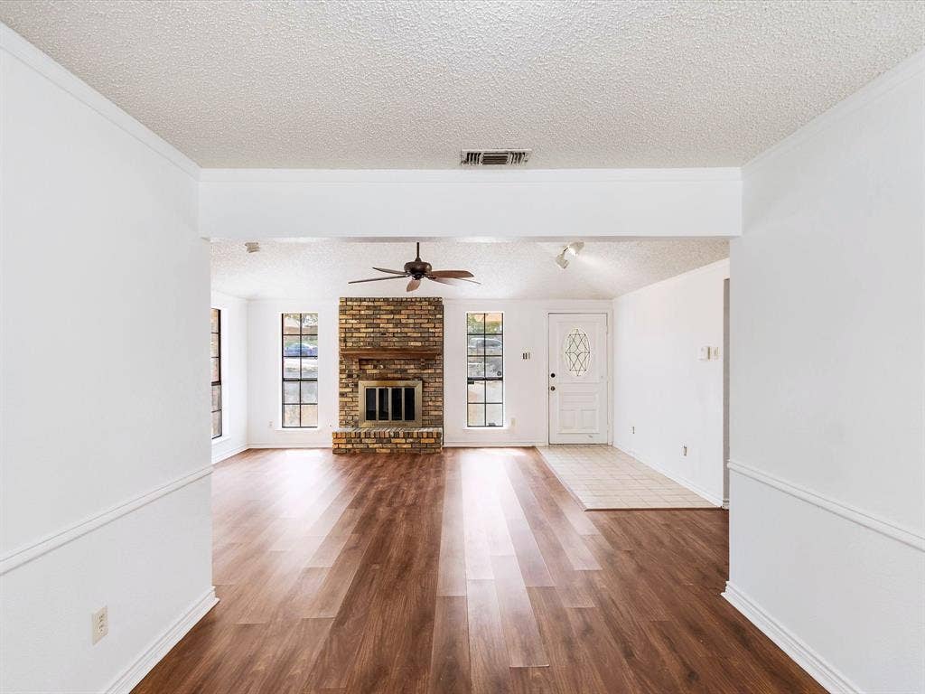 219 N Beltwoods Drive, DeSoto, TX 75115 Wood-finish flooring throughout, complemented by a brick-faced fireplace
